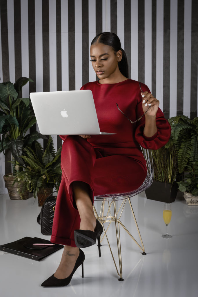 Business woman wearing a red outfit working on her laptop. 