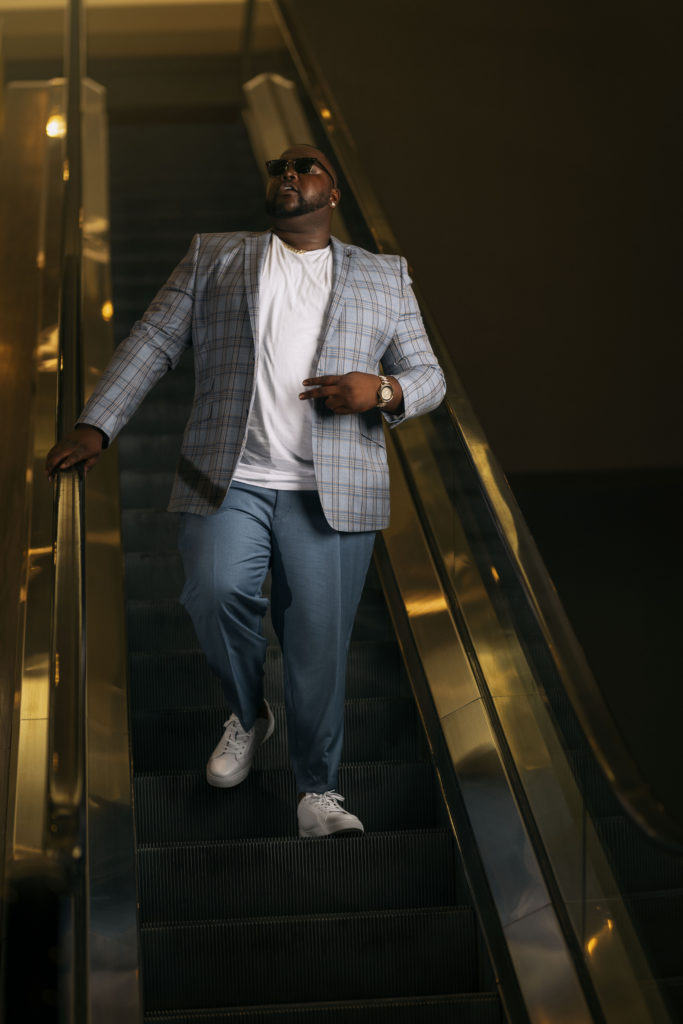 man on escalator wearing a blazer. 