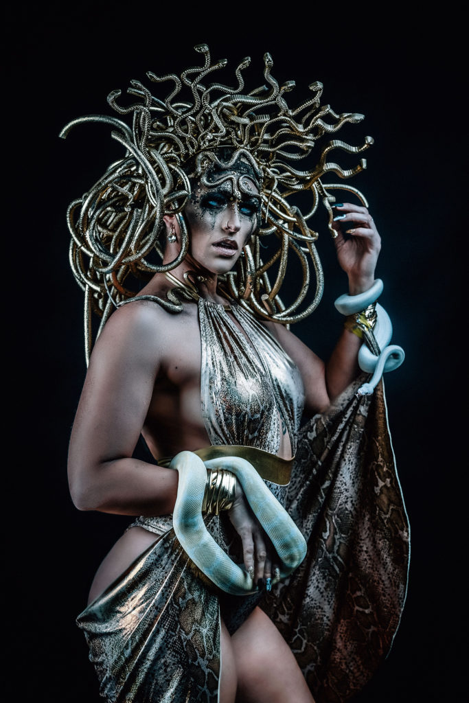 women dressed up for unique halloween photos holding snakes dressed up as Medusa
